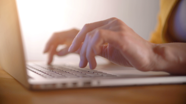 Жінка набирає руки на ноутбук на дерев'яному столі
 - Кадри, відео