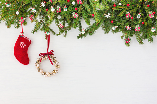 Χριστούγεννα με φόντο. Στολισμένο χριστουγεννιάτικο δέντρο, Χριστουγεννιάτικο στεφάνι και κόκκινης κάλτσας στο λευκό φόντο ξύλινη. Χώρο αντίγραφο - Φωτογραφία, εικόνα