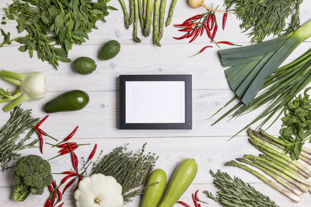 Empty photo frame on table with veggies - Zdjęcie, obraz