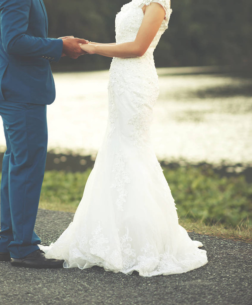 Наречений тримає руку своєї нареченої під час церемонії одруження
 - Фото, зображення