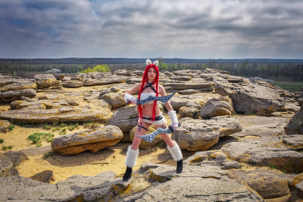 Красивий жіночий персонаж з двома мечами біля великих каменів
  - Фото, зображення
