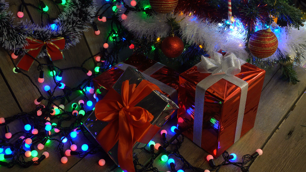 Χριστουγεννιάτικα δώρα κάτω από το χριστουγεννιάτικο δέντρο γκρο πλαν κάμερα Motion λαμπερά φώτα φόντο Bokeh - Πλάνα, βίντεο
