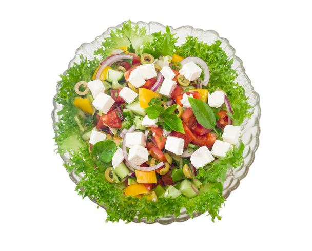 Griekse salade met glas slakom tegen een lichte achtergrond - Foto, afbeelding