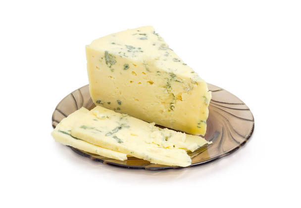 Частично нарезанный голубой сыр на стеклянной тарелке
 - Фото, изображение