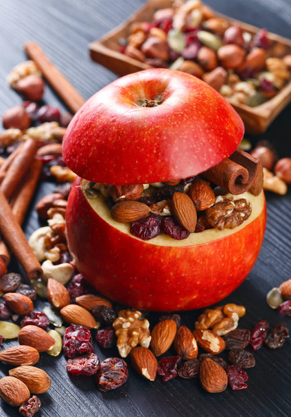 Rode sappige appel met diverse noten, rozijnen en kaneel  - Foto, afbeelding
