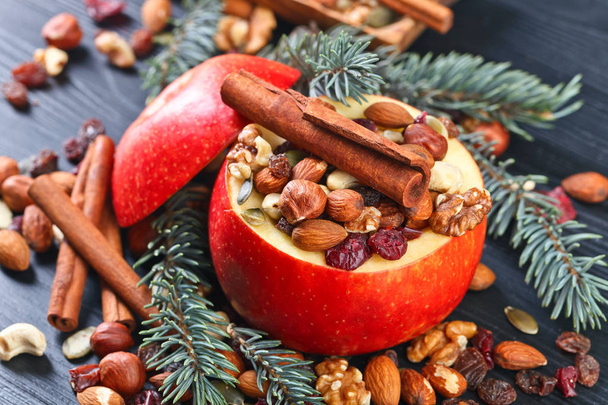 Red juicy apple with assorted nuts , raisins and cinnamon  - Photo, Image