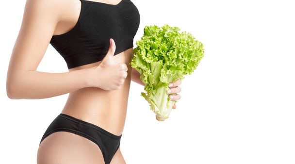 gezonde vrouw met salade bladeren - Foto, afbeelding