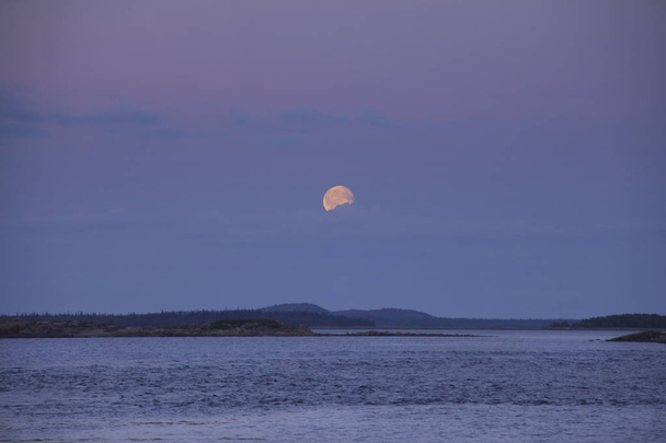 Moon in the clouds over the islands - Фото, изображение