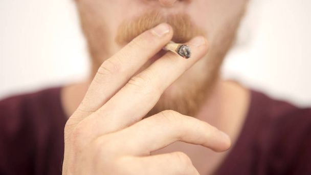 closeup of young man smoking a joint - Foto, Bild