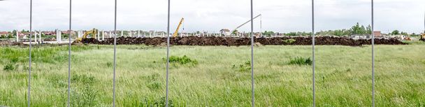 Panorámás kilátás nyílik az építkezés helyén átmenő egy kerítés drót - Fotó, kép