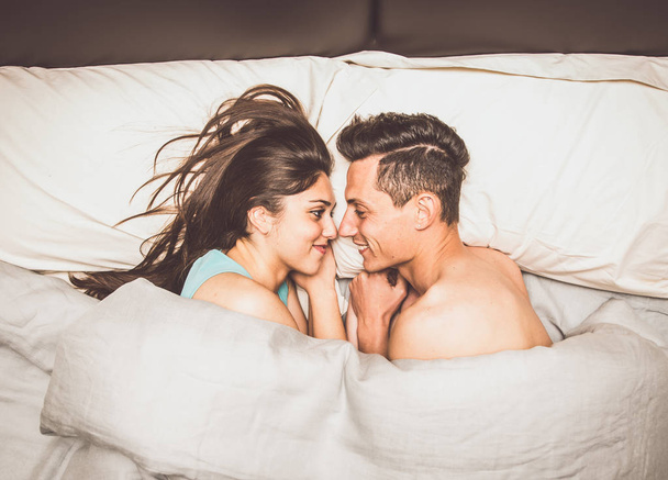 Beautiful young couple in bed - Фото, изображение