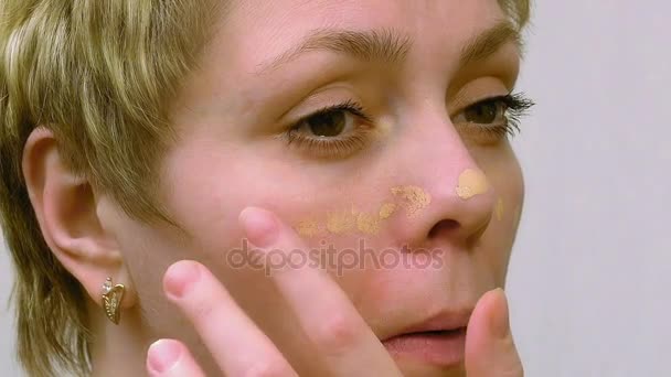 Woman applies makeup concealer foundation cream - Footage, Video