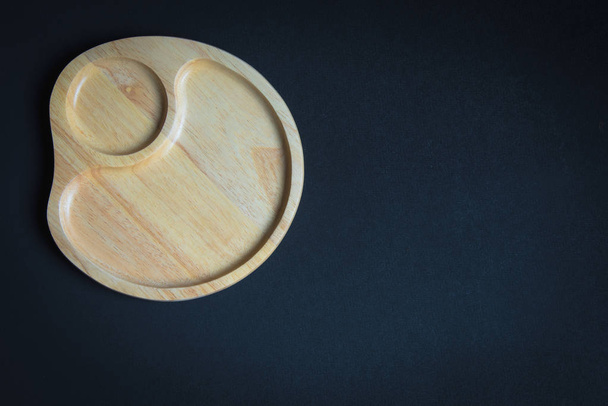Ξύλινο πιάτο στο ξύλινο τραπέζι - Φωτογραφία, εικόνα