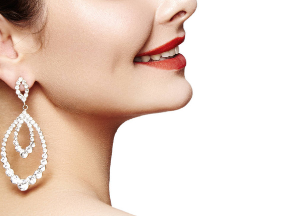 Beautiful happy woman in luxury fashion earrings. Diamond shiny jewelry with brilliants. Sexy retro style portrait. Model with glamour accessories jewelery and bright red lips makeup - Foto, Imagen