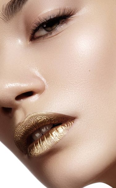 Closeup portrait with of beautiful woman face. Gold color of fashion lip makeup, clean shiny skin and glitter lipgloss. Makeup and cosmetic. Beauty style - Foto, immagini