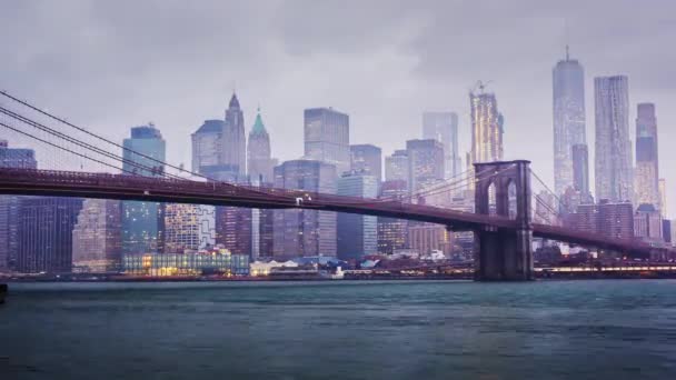 Timelapse dzień i w nocy. Deszczowa Manhattan i Brooklyn Bridge. Na szczytach wieżowców w chmurach utopić. Nadchodzi noc do biznesowej dzielnicy New York City, światła. Tam jest deszcz, ciężki - Materiał filmowy, wideo