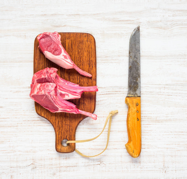 Raw Lamb Chops with Butcher Knife - Foto, afbeelding