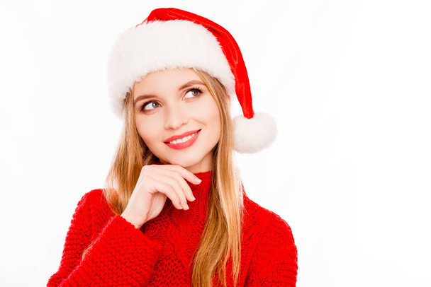 Portrait of minded woman in santa hat dreaming about gifts - Фото, изображение