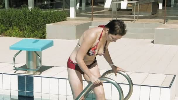 Una señora en bikini rojo sale de la piscina
 - Metraje, vídeo