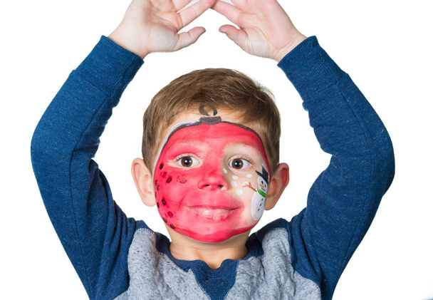 entzückendes Kind mit Bildern im Gesicht als Kugelschreiber mit  - Foto, Bild
