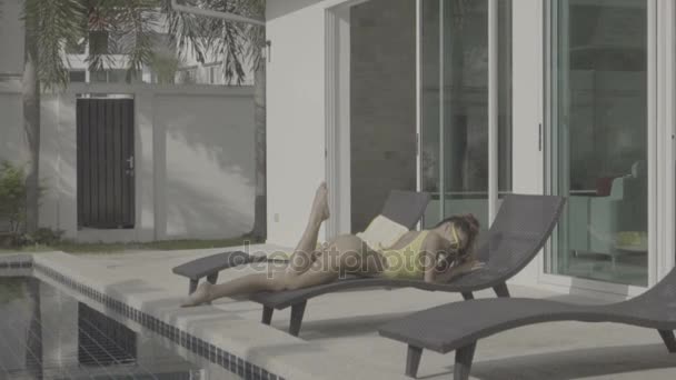 Seksikäs nainen keltainen uimapuku uima-altaalla - Materiaali, video