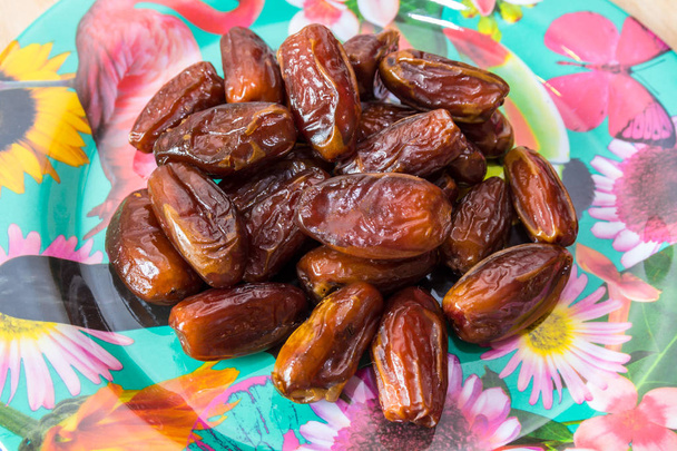 pile of dates on a floral plate - Photo, Image