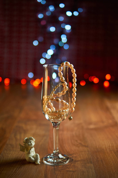 Glass of champagne and beads - 写真・画像
