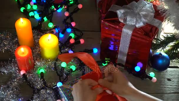 Γυναίκα στην ΚΓΠ Santa αναδιπλώνεται χριστουγεννιάτικα δώρα κάτω από το χριστουγεννιάτικο δέντρο - Πλάνα, βίντεο