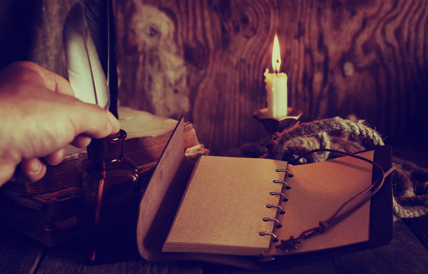 ρετρό αντικείμενα φτερό και leaher βιβλίο με φως των κεριών - Φωτογραφία, εικόνα