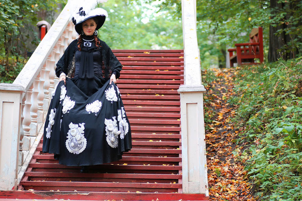 κορίτσι στο παλιό ρετρό φόρεμα στις εξωτερικές σκάλες - Φωτογραφία, εικόνα