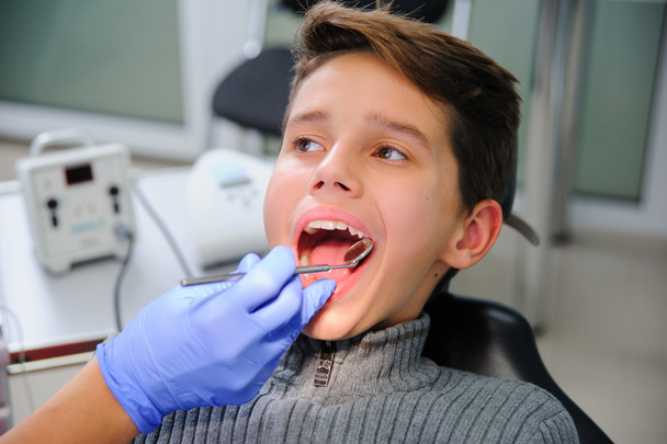 Foto van kleine jongen met mond checkup in tandheelkundige kliniek - Foto, afbeelding