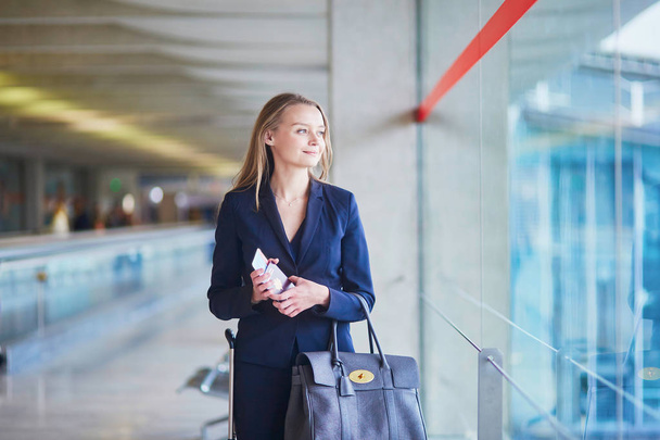 Business woman with passport and boarding pass in international airport - Fotó, kép