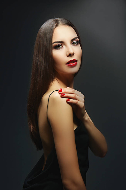 Portrait of beautiful young woman model with bright makeup on dark background - Fotó, kép