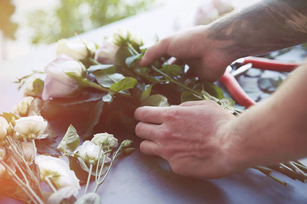 Male florist making bouquet at flower shop - 写真・画像