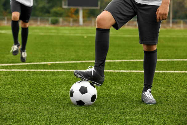 Football player holding ball with foot, closeup - Zdjęcie, obraz