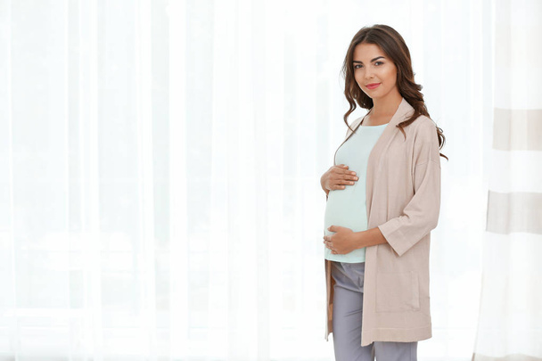 pregnant woman standing near window  - Fotó, kép