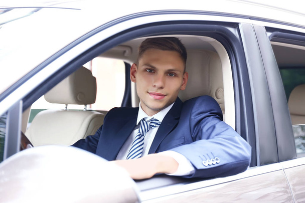 Young businessman looking from car window - Foto, Imagen
