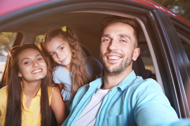 Happy family with daughter taking selfie in car - Fotografie, Obrázek