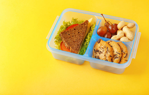 Lunchbox with dinner on yellow table - Photo, image