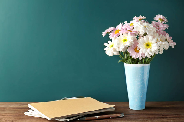Copybooks and flowers on teacher's desk - Фото, зображення