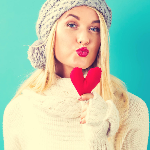 Happy young woman holding a heart cushion - Foto, Imagem