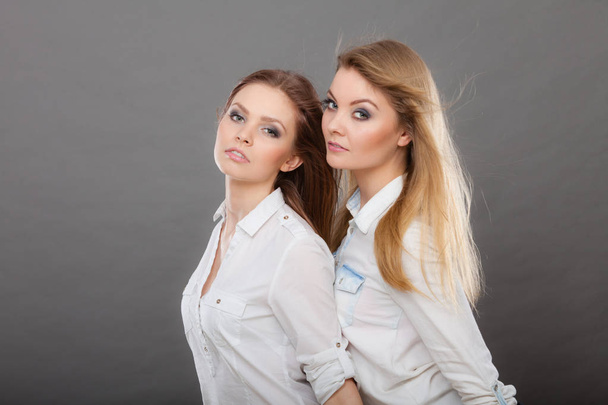 Two beautiful women, blonde and brunette posing - Valokuva, kuva