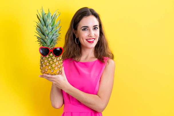 Happy young woman holding a pineapple - Foto, Imagen