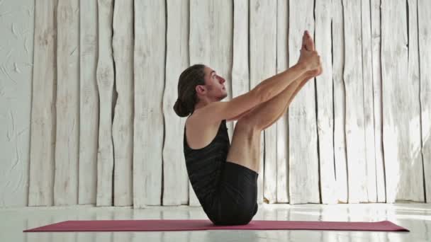 Young sporty man practicing yoga in fitness studio - Footage, Video
