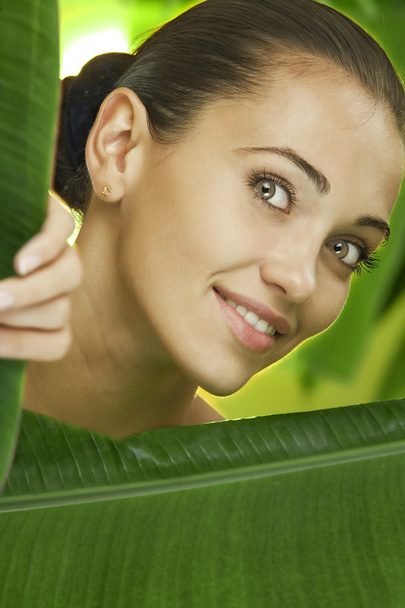 Portrait of young beautiful woman on green leafs back - Photo, Image