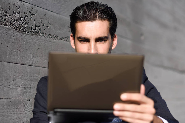 Biznesmen, korzystasz z laptopa, siedząc na ulicy - Zdjęcie, obraz