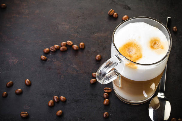 two glasses of latte ad spoons on dark rustic background - Foto, Bild