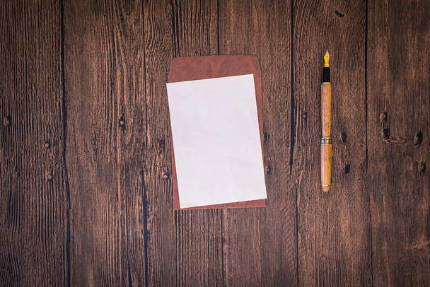 uma mesa de madeira com um caderno, envelopes e outros artigos de papelaria
.  - Foto, Imagem