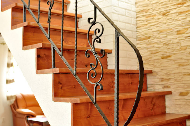 Escalier intérieur en bois avec balustrade ornementale en fer
 - Photo, image