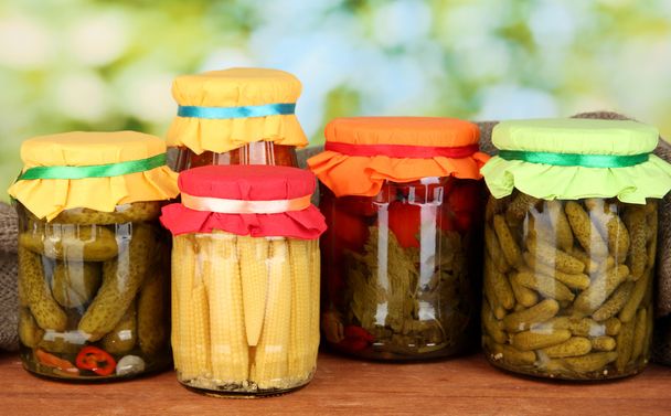 Jars with canned vegetables on green background close-up - Photo, image